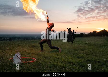 Hügel Von Tara, Irland. Juni 2021. Eine Feuerpause unterhält die Menschen auf dem Hügel von Tara in den letzten Augenblicken vor dem Sonnenuntergang am längsten Tag der nördlichen Hemishalle. EINE große Anzahl von Zuschauern, jung und alt, viele begleitet mit Hunden, Versammelten sich auf dem Hügel von Tara in Co. Meath, um den Sonnenuntergang an der Sommersonnenwende am 21. Juni zu sehen. Der Hügel von Tara ist ein neolithisches Durchgangsgrab und eine Stätte von wichtiger historischer Bedeutung in der irischen Folklore. Kredit: SOPA Images Limited/Alamy Live Nachrichten Stockfoto