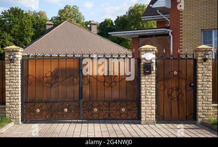 Nette Fassade und schmiedeeisernen Toren bedeckten Polycarbonat in einem privaten Haus Stockfoto