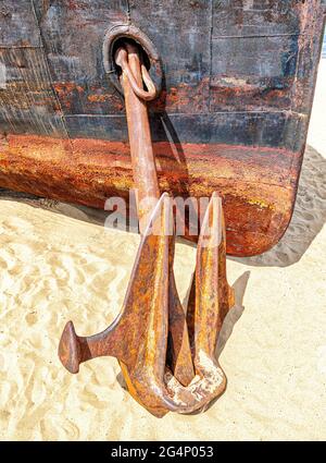 Alter rostiger Anker eines verlassenen Schiffes am Sandstrand im Hafen Stockfoto