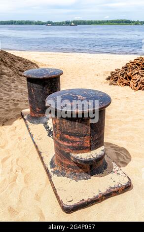Alte rostige Anlegestelle im Hafen am Sandstrand Stockfoto