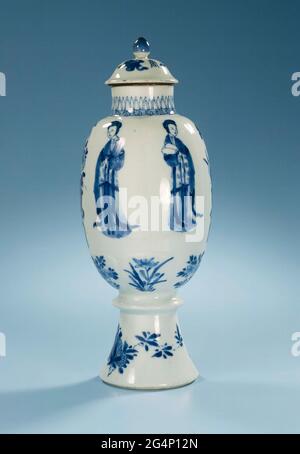 . Eiförmige Porzellan-Deckelstopfen am hohen Fuß mit ringförmiger Verdickung, in Unterglasur blau lackiert. An der Wand sechs modellierte Fächer mit einer chinesischen Dame (lange Läuse) oder einer Blumenvase (Lotus, Chrysantheme); darunter sechs kleinere modellierte Fächer mit Blumen- und Obstsorten; der Fuß mit einer Blume und einem Fruchtnack; am Hals ein Band mit einem Meander-Motiv, über dem spitze Blätter angebracht sind; Der Deckel mit Wertsachen (Diamant, Perle, artimisialabra), zwischen denen drei chinesische Zeichen "Zhou", bedeutungsvoll Bedeutung. Blauweiß. Stockfoto