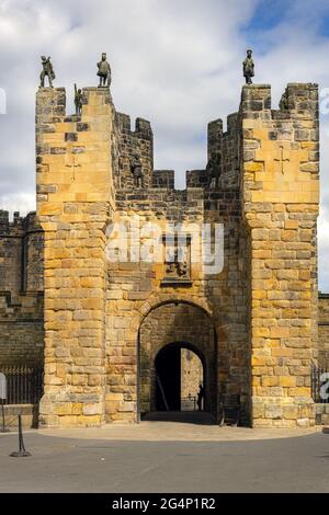 ALNWICK, ENGLAND - 10. JUNI 2021: Statuen von Kriegern auf der Spitze des barbican, Torhaus der Burg Alnwick, Northumberland, England Stockfoto