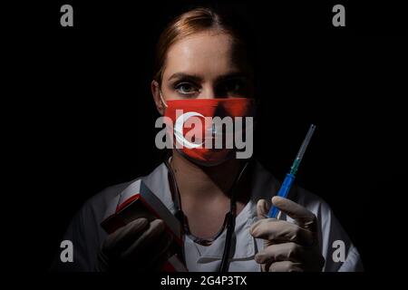Ärztin mit Covid-19-Impfstoff-Turkovac in Händen mit Türkei-Flagge Stockfoto