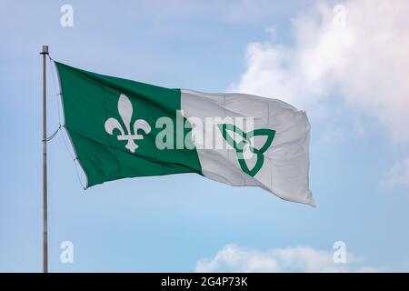 Hawkesbury, Ontario, Kanada - 21. Juni 2021: Die französisch-ontarische Flagge, die französisches kanadisches Erbe in Teilen von Ontario repräsentiert, fliegt auf einem Fahnenmast Stockfoto