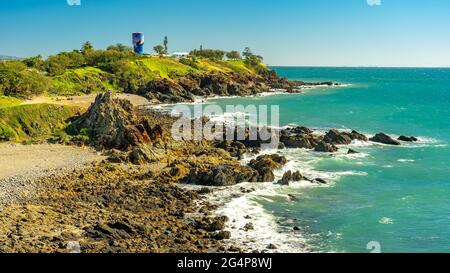 Felsige Küste am Slade Point mit einem Wasserturm im Hintergrund, Queensland, Australien Stockfoto