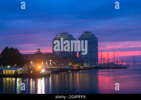 Die geschäftige Hafenpromenade von Halifax Harbour an einem wunderschönen Sommerabend bei einem sehr romantischen Sonnenuntergang. Halifax Waterfront während der goldenen Stunde. Stockfoto