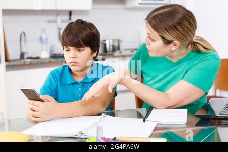 Frau schimpft Jungen in der Küche Stockfoto