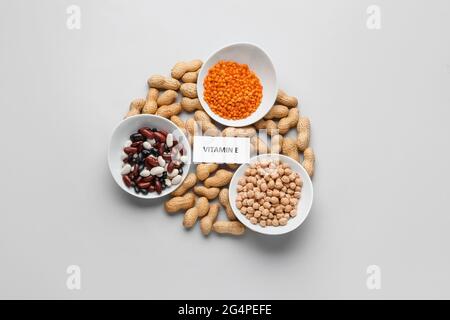 Teller mit verschiedenen gesunden Nüssen und Bohnen, die reich an Vitamin E sind, auf hellem Hintergrund Stockfoto