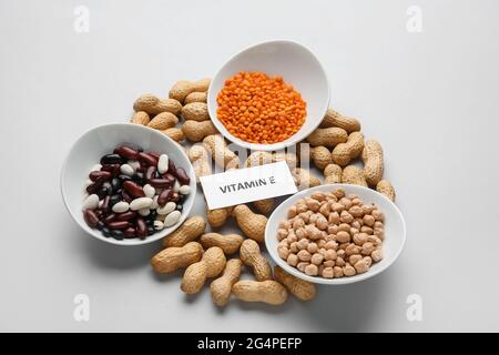 Teller mit verschiedenen gesunden Nüssen und Bohnen, die reich an Vitamin E sind, auf hellem Hintergrund Stockfoto