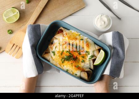 Frau mit heißem Enchilada in Backform Stockfoto