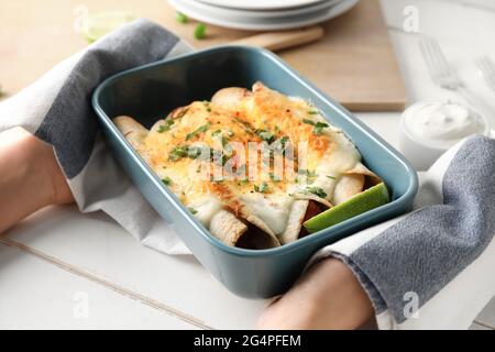 Frau mit heißem Enchilada in Backform Stockfoto