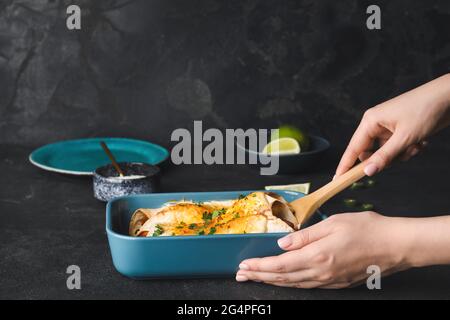 Frau mit heißem Enchilada in Backform Stockfoto