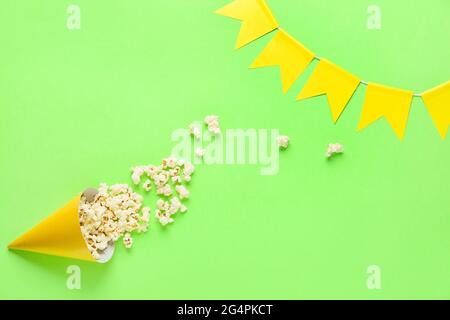 Partykegel mit Popcorn und Girlande auf farbigem Hintergrund. Festa Junina (Junifest) Feier Stockfoto