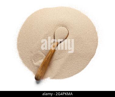 Haufen aktiver Trockenhefe und Holzlöffel auf weißem Hintergrund Stockfoto