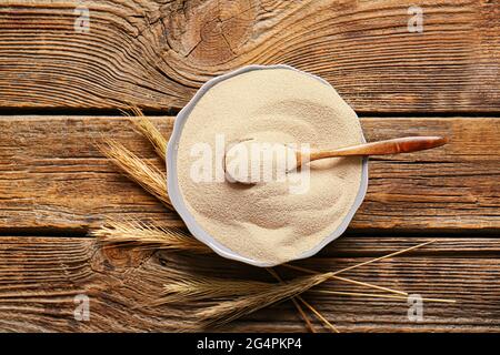 Schüssel mit aktiver Trockenhefe auf Holztisch Stockfoto