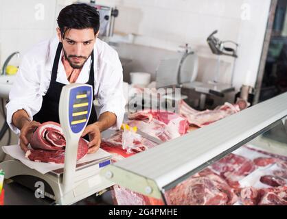 Der Metzger legt Fleisch auf Schuppen Stockfoto