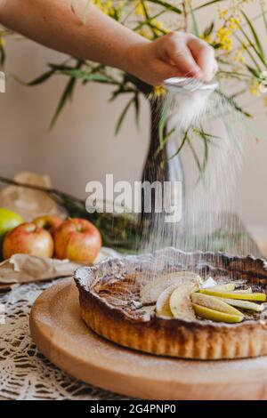 Rustikaler Apfelkuchen, serviert mit Eis und Beeren mit Tellernblumen. Serviert auf einem faulen Susan Holzteller. Stockfoto