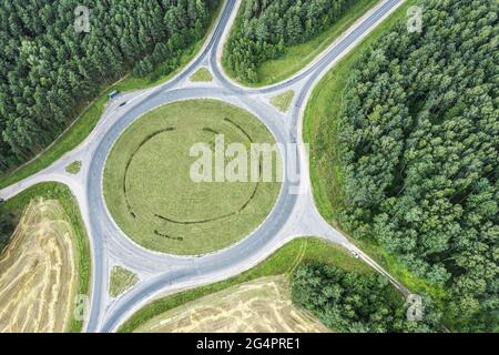 Luftaufnahme eines leeren Kreisels im ländlichen Raum zwischen Ackerfeld und Wald Stockfoto