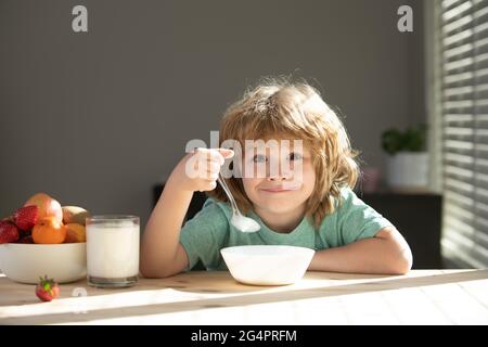 Kind, das gesunde Nahrung isst. Netter kleiner Junge, der zum Mittagessen Suppe hat. Stockfoto