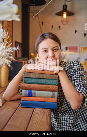 Mädchen in einem Café mit Büchern müde von der Arbeit Stockfoto
