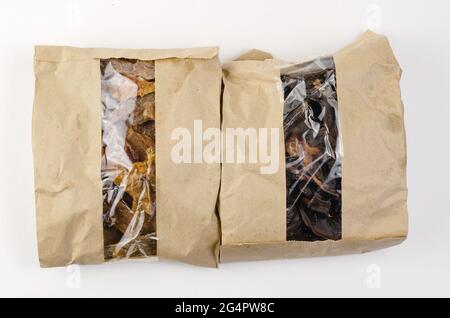 Zwei Päckchen Hundefutter auf weißem Hintergrund. Braune Papiertüten mit Fenster. Getrocknete Rindernieren und Euterstücke von Rindern. Stockfoto