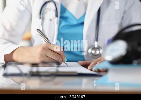 Der Arzt macht sich Notizen zur Nahaufnahme der Krankenakten Stockfoto