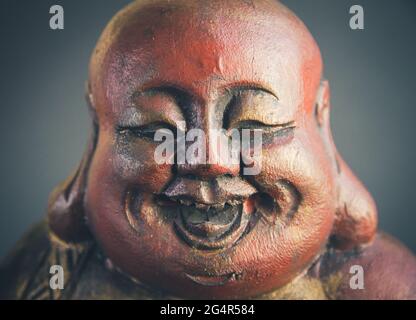 Traditionelle Holzstatue des chinesischen Buddha isoliert auf dunklem Hintergrund Stockfoto