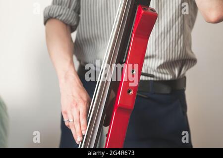 Hände eines Mannes, der roten elektrischen Kontrabass spielt. Nahaufnahme mit selektivem Fokus. Live-Musik im Hintergrund Stockfoto