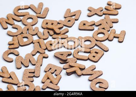 Viele Holzbuchstaben auf weißem Hintergrund aus nächster Nähe Stockfoto