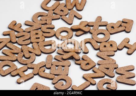 Viele Holzbuchstaben auf weißem Hintergrund aus nächster Nähe Stockfoto