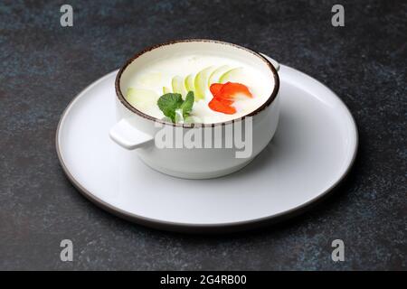 Leckere Haferflocken mit Apfel, Erdbeere und Minze in einer Schüssel auf dem Tisch Stockfoto