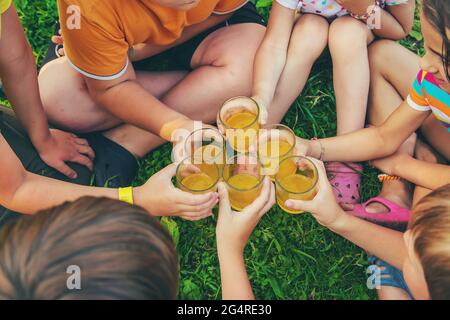 Die Kinder trinken gemeinsam Limonade auf der Straße. Selektiver Fokus. Kinder. Stockfoto