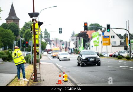 23. Juni 2021, Nordrhein-Westfalen, Sprockhövel-Haßlinghausen: Zwei Mitarbeiter von Straßen.NRW installieren am Rathausplatz eine Kamera für videobasierte Verkehrszählungen. Derzeit findet in ganz Deutschland die Zählung des Straßenverkehrs statt. In jüngster Zeit setzt Straßen.NRW zu diesem Zweck zunehmend Radar- und videobasierte Methoden ein. Foto: Jonas Güttler/dpa Stockfoto