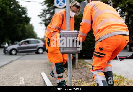 23. Juni 2021, Nordrhein-Westfalen, Sprockhövel-Haßlinghausen: Zwei Mitarbeiter von Straßen.NRW bauen auf dem Rathausplatz ein radarbasiertes Verkehrszählgerät. Derzeit findet in ganz Deutschland die Zählung des Straßenverkehrs statt. In jüngster Zeit setzt Straßen.NRW zu diesem Zweck zunehmend Radar- und videobasierte Methoden ein. Foto: Jonas Güttler/dpa Stockfoto