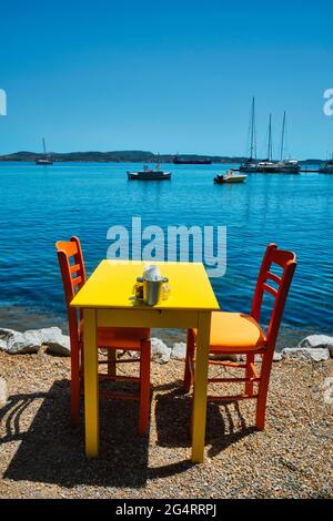 Café Tableon Strand in Adamantas Stadt auf Milos Insel mit Ägäis mit Booten im Hintergrund Stockfoto