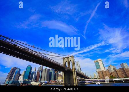 Brooklyn Bridge unter blauem Himmel und weißen Wolken, Blick auf Stadtgebäude.EINE berühmte Ansicht von New York City, USA Oktober 2016. Stockfoto