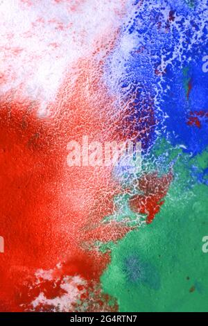 Tropfen mit Streifen verschiedener Farben werden gemischt und absorbiert Stockfoto