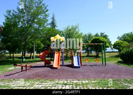 Kinderspielplatz im Freien an einem sonnigen Tag inmitten von Bäumen Stockfoto