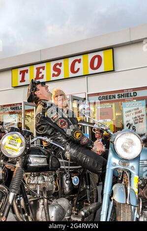 Motorradfahrer in Vintage Motorradbekleidung mit klassischen Motorrädern beim Goodwood Revival 2011, vor dem Tesco Store Umbau. Lachend Stockfoto