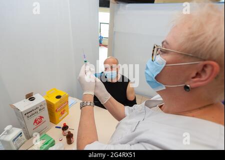 Lviv, Ukraine 23. Juni 2021. Ein Mitarbeiter im Gesundheitswesen wendet eine Dosis Coronavac-Impfstoff auf einen Mann an. Stockfoto