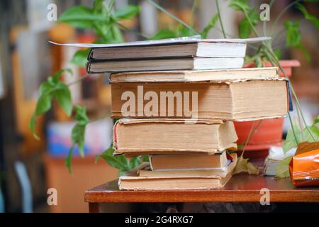 Alte Bücher stapeln sich auf einem Holztisch. Selektiver Fokus Stockfoto