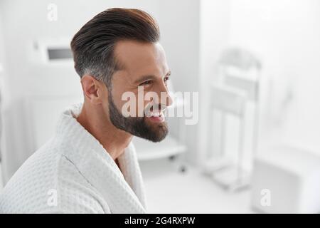 Reife Person trägt Bademantel wartet auf Hautpflege-Verfahren im Salon Stockfoto