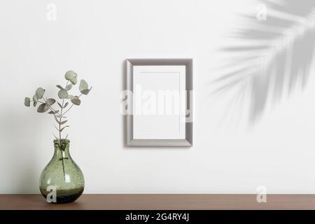 Leerer Rahmenhintergrund nachahmen. Leerer dekorativer Rahmen für ein Foto oder Gemälde in einem hellen skandinavischen minimalistischen Interieur an einer weißen, sauberen Wand. Hochwertige Fotos Stockfoto