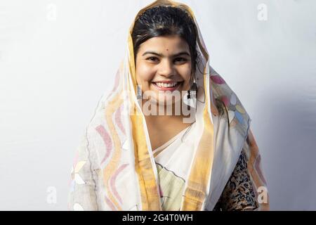 Eine schöne indische Frau in Saree isoliert auf weißem Hintergrund Posen mit lächelndem Gesicht Stockfoto