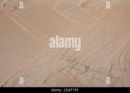 Schlammiges Wasser, das nach dem Regen aus den Straßen fließt. Stockfoto