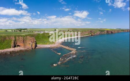 Luftaufnahme des Dorfes Auchmithie auf den Klippen und des Strandes und des alten Hafens. In Auchmithie wurde der Arbroath Smokie zum ersten Mal hergestellt. Stockfoto