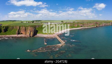 Luftaufnahme des Dorfes Auchmithie auf den Klippen und des Strandes und des alten Hafens. In Auchmithie wurde der Arbroath Smokie zum ersten Mal hergestellt. Stockfoto