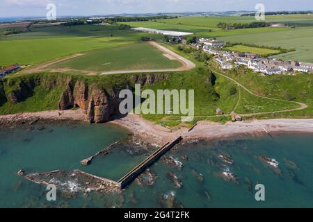 Luftaufnahme des Dorfes Auchmithie auf den Klippen und des Strandes und des alten Hafens. In Auchmithie wurde der Arbroath Smokie zum ersten Mal hergestellt. Stockfoto