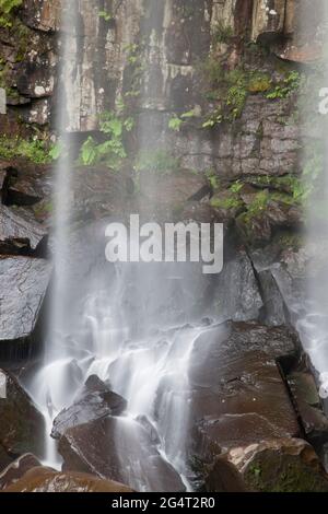 Melincourt Waterfalls, Neath, Wales, aufgenommen mit einer langsamen Verschlusszeit, um die Wasserbewegung zu zeigen, während es auf Felsen herunterstürzt Stockfoto