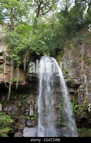 Melincourt Waterfalls, Neath, Wales, wird mit einer normalen, schnellen Verschlusszeit aufgenommen, um das Wasser einzufrieren, während es auf Felsen stürzt Stockfoto